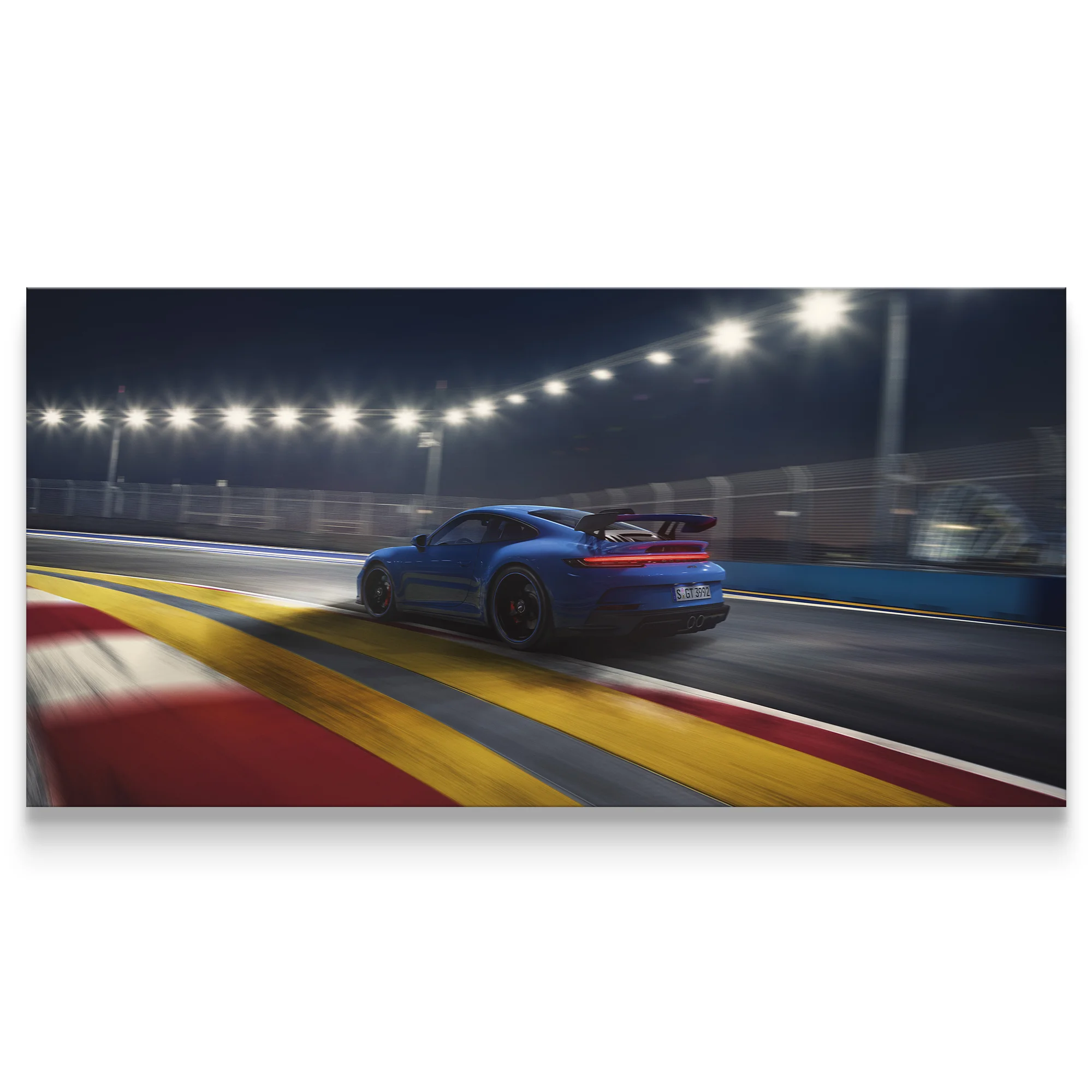 Blue sports car on a race track at night with illuminated lights.